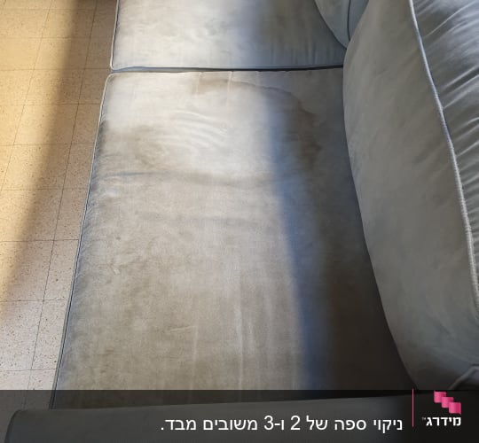 ספה אפורה עם כתמי לכלוך נראים לעין